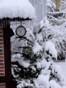 Uhr im Schnee mit Eiszapfen